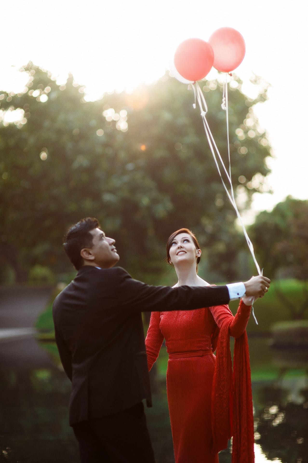 couple are standing and holding balloon