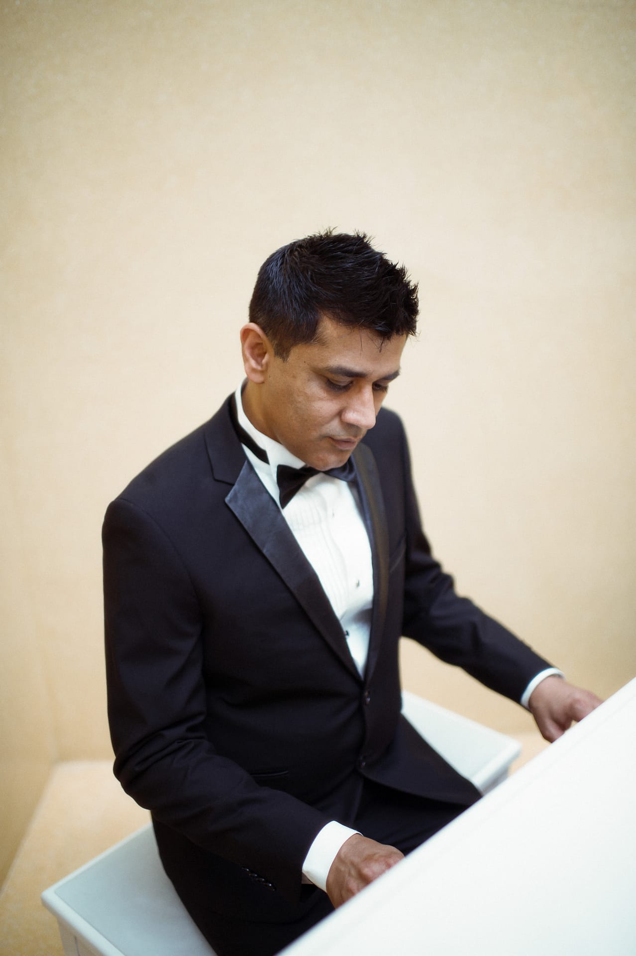Groom playing piano for her bride